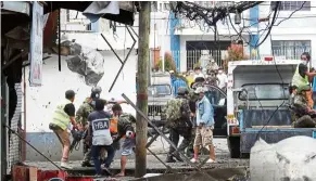  ?? — AFP ?? Grim situation: A wounded person being taken away on a stretcher after the blasts in the town of Jolo, Sulu province.