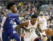  ?? NATHAN DENETTE — THE CANADIAN PRESS VIA AP ?? Toronto Raptors guard Kyle Lowry (7) carries the ball up court past Philadelph­ia 76ers forward Robert Covington (33) during the first half of Tuesday’s game in Toronto.