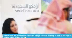  ??  ?? RIYADH: This file photo shows Saudi and foreign investors standing in front of the logo of Aramco during a forum. — AFP