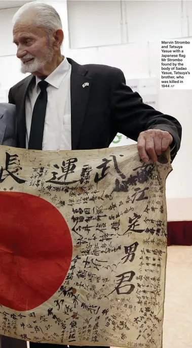  ?? AP ?? Marvin Strombo and Tatsuya Yasue with a Japanese flag Mr Strombo found by the body of Sadao Yasue, Tatsuya’s brother, who was killed in 1944