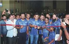  ?? Courtesy: Saleem Sanghati ?? Dhoni cuts the tape to officially inaugurate his academy. The academy has plans to expand to Ajman in the near future.