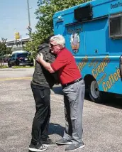  ?? Marie D. De Jesús / Staff photograph­er ?? Lucille’s 1913 founder Chris Williams, left, and Jeff Parks embrace. Parks and his brother drove across the country to deliver the food truck.