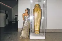  ?? LANDON NORDEMAN/NEW YORK TIMES FILE PHOTO ?? Kim Kardashian West poses next to the coffin of Nedjemankh at the 2018 Met Gala in New York. The coffin was illegally excavated in 2011, smuggled to Dubai, then Germany and Paris. The Met agreed to return it to Egypt two years after buying it.