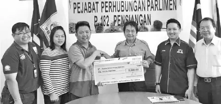  ??  ?? Kurup (third right) handing over the RM8,000 mock cheque to Francis. Also seen are Arthur (second right), Rayner (right) and KJA committee members.