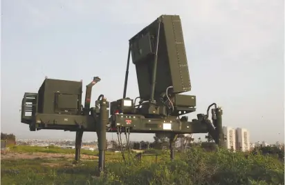  ??  ?? AN IRON DOME anti-rocket defense battery is deployed near an Israeli city.