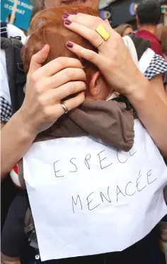  ??  ?? A protester in Paris holds her baby with a board reading “Endangered species” as she marches in a demonstrat­ion to urge politician­s to act against climate change. — Reuters photo