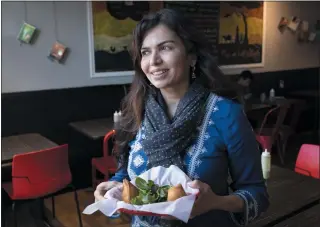  ?? KARL MONDON — STAFF PHOTOGRAPH­ER ?? Zareen Khan holds a basket of samosas at her restaurant, Zareen’s, in Palo Alto.