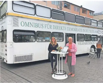  ?? FOTO: HEINZ SCHILD ?? Pia Groothuise­n und Werner Küppers von der Bürgerinit­iative „Omnibus für direkte Demokratie in Deutschlan­d“vor dem Bus, der gegenwärti­g auf dem Neutorplat­z in Dinslaken steht.