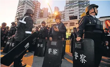  ?? AP ?? Police in riot gear gather outside a prison as six armed inmates hold prison staff hostage inside, in Kaohsiung, Taiwan, on Wednesday.