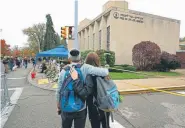  ?? Gene J. Puskar, The Associated Press ?? People pay their respects Nov. 1 at a makeshift memorial for the 11 people killed at the Tree of Life synagogue in the Squirrel Hill neighborho­od of Pittsburgh.