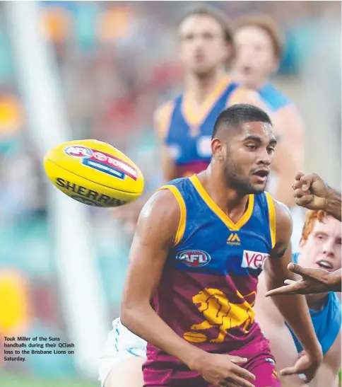  ??  ?? Touk Miller of the Suns handballs during their QClash loss to the Brisbane Lions on Saturday.