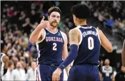  ?? JOHN LOCHER/ASSOCIATED PRESS ?? Gonzaga’s Drew Timme and Julian Strawther celebrate during Thursday’s Sweet 16 79-76 win against UCLA in Las Vegas. “One shining moment,” Timme said of Strawther’s 3-pointer.