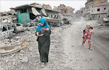  ?? AHMAD AL-RUBAYE/GETTY-AFP ?? An Iraqi woman carries a child as they flee Friday from the Old City of Mosul. Some 20,000 civilians remain in their homes even as Iraqi troops fight to liberate Mosul.