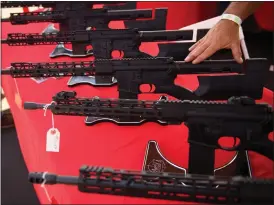  ?? PATRICK T. FALLON — AFP VIA GETTY IMAGES ?? A TPM Arms LLC California-legal featureles­s AR-15style rifle is displayed for sale at the company's booth at a gun show at the Orange County Fairground­s in 2021.