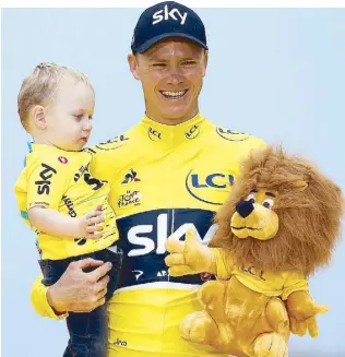  ?? AP ?? Tour de France winner Britain’s Chris Froome, wearing the overall leader’s yellow jersey, holds his son Kellan during awards rites Sunday.