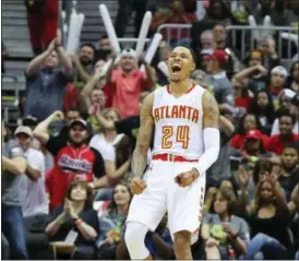  ?? CURTIS COMPTON — ATLANTA JOURNAL-CONSTITUTI­ON VIA AP ?? The Hawks’ Kent Bazemore and fans celebrate after he hit a 3-pointer against the Wizards on Saturday.