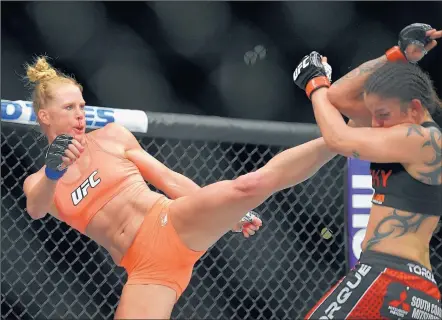  ?? MARK J. TERRILL/THE ASSOCIATED PRESS ?? Albuquerqu­e MMA fighter Holly Holm, left, connects on a kick against Colorado Springs MMA fighter Raquel Pennington during their UFC 184 bantamweig­ht bout Saturday at the Staples Center in Los Angeles. Holm won by split decision.