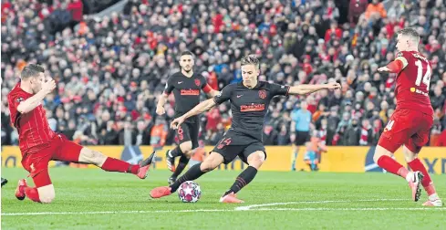  ?? AFP ?? Atletico Madrid’s Marcos Llorente, centre, scores his team’s second goal against Liverpool at Anfield.