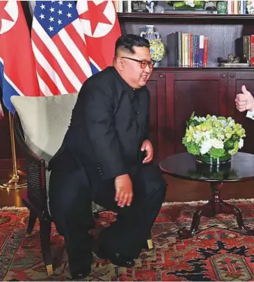  ??  ?? Above: US President Donald Trump gives a thumbs up as he sits down with North Korea’s leader Kim Jong-un for their historic US-North Korea summit, at the Capella Hotel on Sentosa island in Singapore yesterday.