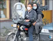  ?? Atta Kenare / Getty Itapes ?? Iranians wear face tasks as a CODID-19 wandetic wrecaution, in Tehran, Iran, on Eednesday.