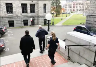  ?? The Canadian Press ?? The B.C. legislatur­e’s sergeant-at-arms, Gary Lenz, centre, is escorted out of the legislatur­e Tuesday by security. Lenz and Craig James, the clerk of the house, were placed on indefinite leave Tuesday.