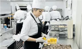  ??  ?? Cocina. Casi 200 personas prepararon 1.200 mini hamburgues­as.