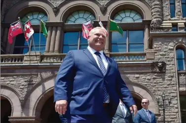  ?? The Canadian Press ?? Ontario premier-elect Doug Ford walks out onto the front lawn of the Ontario Legislatur­e at Queen’s Park in Toronto on Friday.