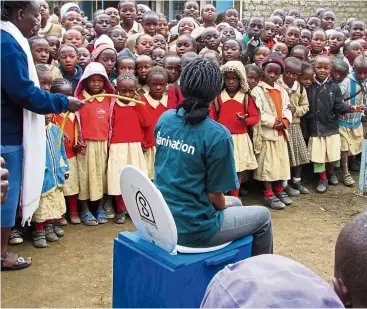  ??  ?? It’s very simple: a woman shows how to use Sanivation’s blue box toilets.