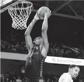  ?? Willie J. Allen Jr. / Associated Press ?? UH center Chris Harris Jr. closes in for the dunk as Central Florida's Frank Bertz tries to figure out where his defensive assignment went Thursday night.