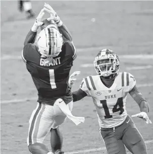  ?? RYAN M. KELLY/GETTY IMAGES ?? Virginia cornerback Nick Grant intercepts a pass intended for Duke's Dennis Smith during a Sept. 26 game. Duke quarterbac­k Chase Brice has thrown three TD passes and seven picks this season.