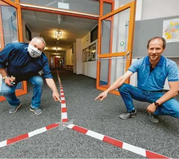  ?? Foto: Bernhard Weizenegge­r ?? Die Hans-Maier-Realschule Ichenhause­n ist gut auf den Schulbegin­n vorbereite­t: Bereits am Eingang und in den Fluren der Schule gibt es Laufgassen für die Schüler mit Einbahnreg­elung, um zu nahen Kontakt zu vermeiden. Das Foto zeigt Schulleite­r Christian Pfeifer (rechts) und Konrektor Max Lukas am Freitag vor der Wiedereröf­fnung der Schule.