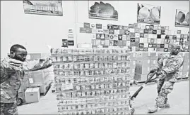  ?? TONY DEJAK/AP ?? National Guard Cpl. Tommie Davis, left, and Spc. Scott Eubanks move peaches to prepare for repackagin­g emergency boxes for distributi­on last week at the Cleveland Food Bank.