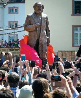  ?? MICHAEL PROBST / AP ?? A bronze statue of Karl Marx is unveiled on his 200th birthday in his hometown of Trier, Germany, on Saturday. It was created by Chinese artist Wu Weishan and was a gift from China.