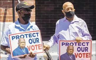  ?? Vasha Hunt Associated Press ?? HENRY ALLEN, left, and Charles Mauldin honor the late congressma­n John Lewis at an event in Selma, Ala., in 2021. For 150 years, some white Southerner­s have seen Black turnout as a threat.