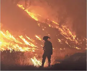  ?? JOSH EDELSON, AP ?? CalFire firefighte­r Bo Santiago lights a backfire as the Rocky blaze burns Aug. 3, 2015, near Clearlake, Calif.
