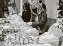  ?? Brett Coomer / Staff photograph­er ?? First lady Jill Biden helps pack a Backpack Buddy meal with volunteers at the Houston Food Bank on Friday.