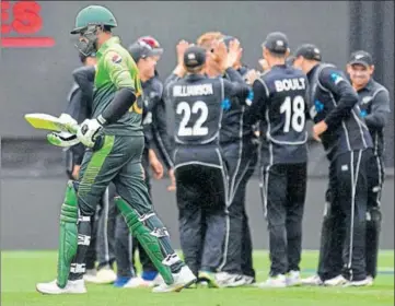  ??  ?? Pakistan's Shoaib Malik (left) walks past a celebratin­g New Zealand team in the third ODI in Dunedin on Saturday.