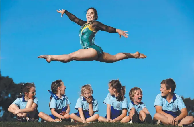  ?? Picture: ADAM HEAD ?? Georgia Godwin displays her skill to pupils at Merrimac State School, where her love of gymnastics began.