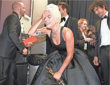  ?? IMAGESMAGE­S MATT SAYLES/AMPAS VIA GETTY ?? An emotional Lady Gaga clutches her Oscar for best original song (“Shallow”) backstage.