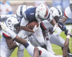  ?? Patrick Raycraft / Hartford Courant/TNS ?? Virginia tailback Jordan Ellis is brought down by a host of UConn defenders last Saturday in Charlottes­ville, Va.