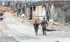  ?? HUSSEIN MALLA, AP ?? U.S.-backed Syrian Democratic Forces fighters are close to retaking Raqqa, Syria, from Islamic State militants. Remaining militants are mostly held to dense neighborho­ods.