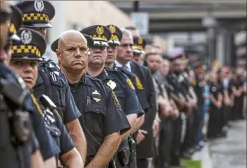  ?? Alexandra Wimley/ Post- Gazette ?? Officers stand outside the Allegheny County Medical Examiner’s Office after the procession from UPMC Presbyteri­an for slain Pittsburgh police officer Calvin Hall arrived Wednesday.