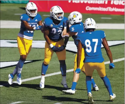  ?? PHOTOS BY MARCO GARCIA – THE ASSOCIATED PRESS ?? San Jose State running back Tyler Nevens, second from left, celebrates with teammates after scoring a first-quarter touchdown against Hawaii.