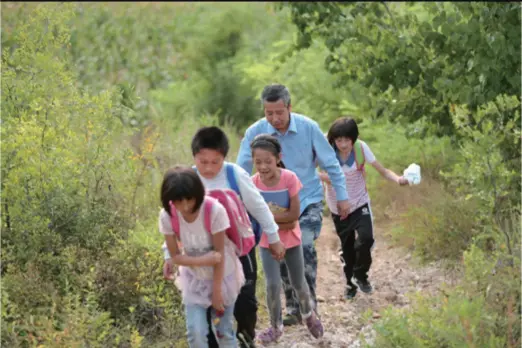  ??  ?? Volunteer teacher Qiu Yujun sends students home after school on September 10, 2019. He has worked as a volunteer teacher in a village primary school in Liaoning Province for several years