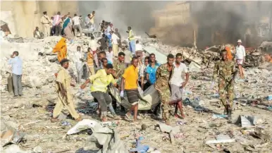  ??  ?? Rescue operation at the site where a bomb was detonated inside a truck in the centre of Mogadishu, Somalia yesterday. The bomb exploded outside a hotel at a busy junction, causing widespread devastatio­n that left at least 20 dead, with the toll likely...