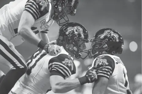  ?? AARON VINCENT ELKAIM/THE CANADIAN PRESS ?? The Tiger-Cats’ Matt Coates, centre, celebrates a first-quarter touchdown with teammates during Friday night’s victory over the Argos.