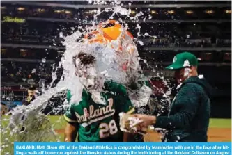  ?? — AFP ?? OAKLAND: Matt Olson #28 of the Oakland Athletics is congratula­ted by teammates with pie in the face after hitting a walk off home run against the Houston Astros during the tenth inning at the Oakland Coliseum on August 17, 2018.