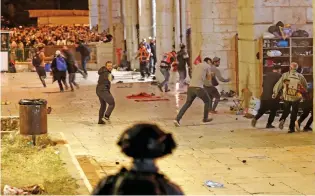  ?? (AFP) ?? Israeli security forces clash with Palestinia­n protesters at the Al Aqsa Mosque compound, in Jerusalem on Friday