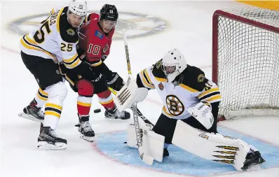  ?? COLOR CHINA, VIA THE ASSOCIATED PRESS ?? Brandon Carlo, left, and goalie Jaroslav Halak of the Boston Bruins and Derek Ryan of the Calgary Flames battle for the puck during an exhibition game in Shenzhen, China on Saturday. Boston won 4-3 in a shootout.