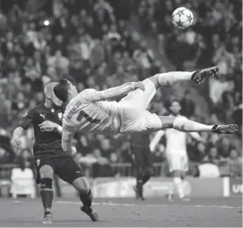  ?? PIERRE-PHILIPPE MARCOU/AFP/GETTY IMAGES ?? Real Madrid’s Cristiano Ronaldo goes airborne to maintain possession against Malmo in Champions League play.